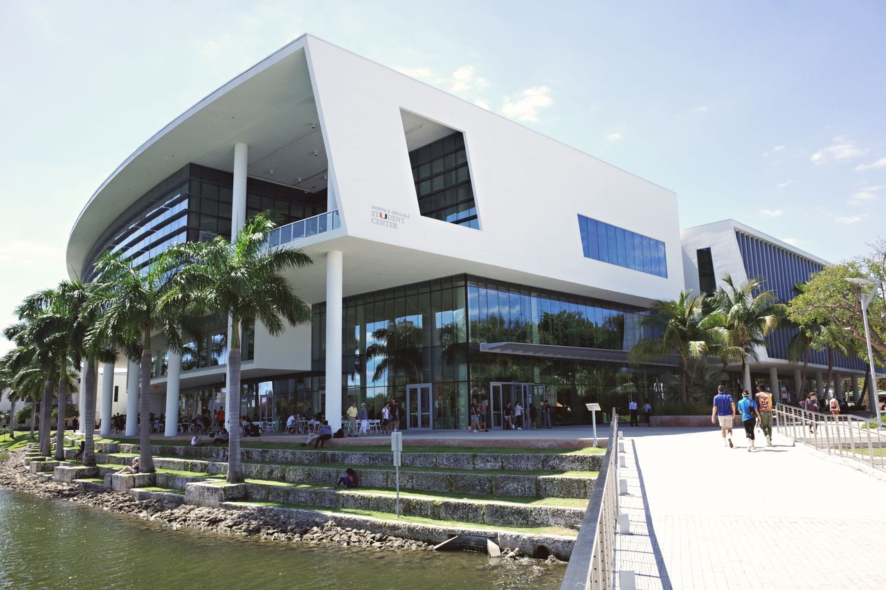 University building with glass facade and palm trees in Coral Gables, Florida.